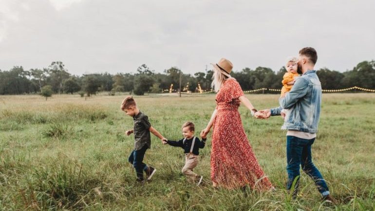 A family with kids walking in the fields