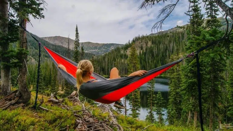 A woman relaxing in a forest near a river