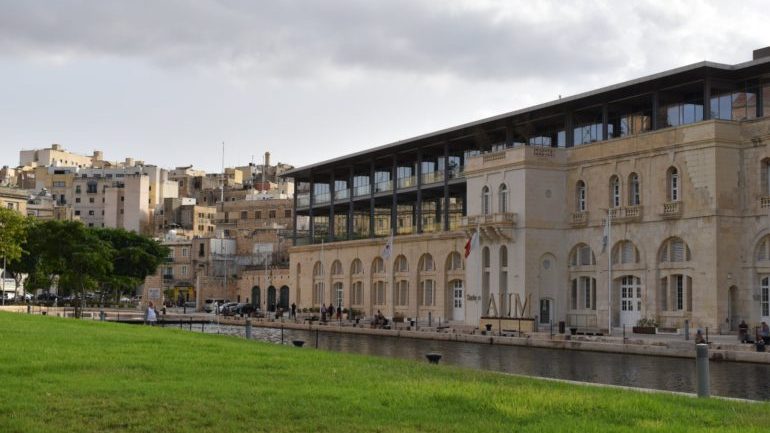 Green field in front of the American University of Malta