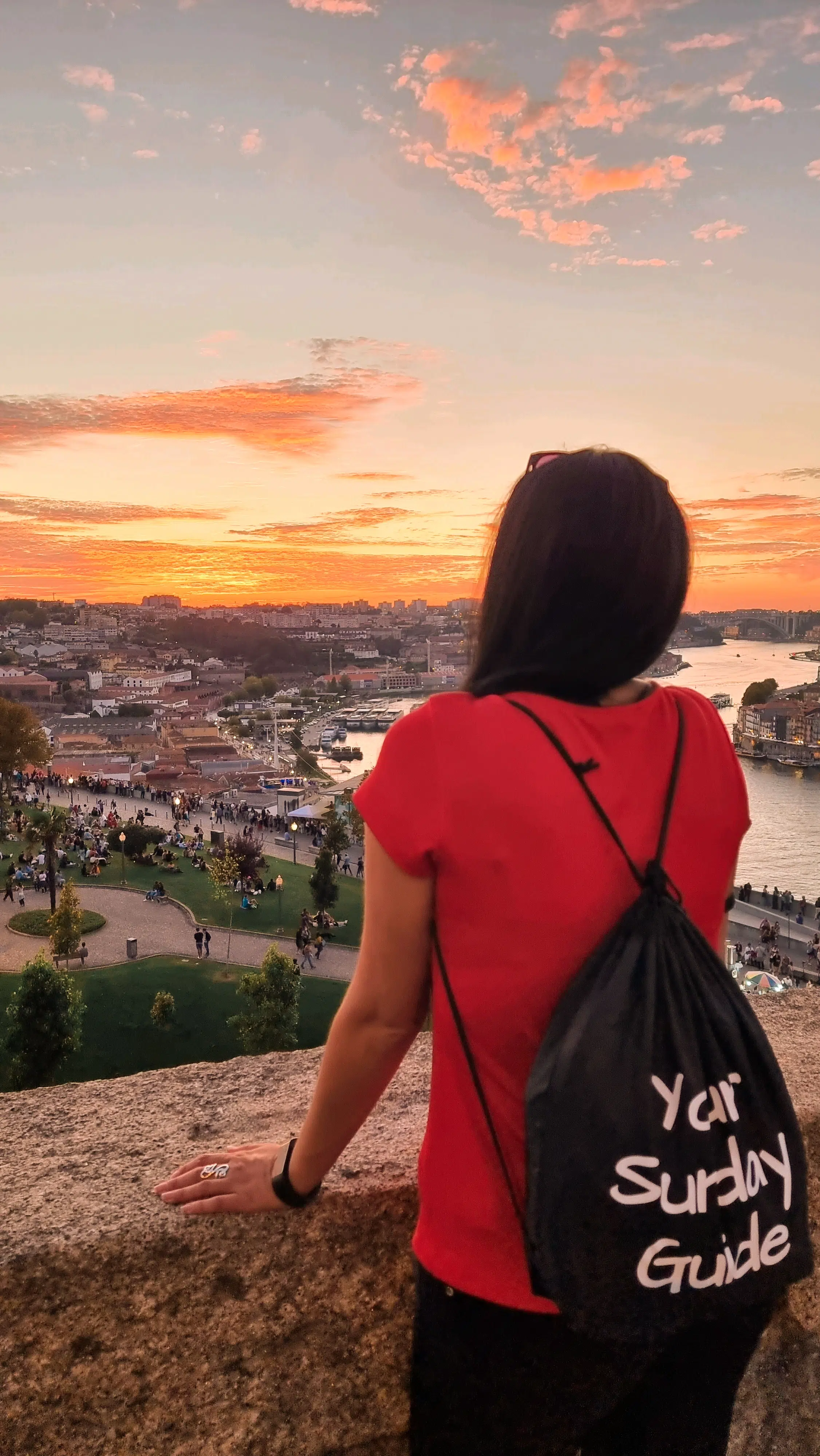 A woman watching the sunset over a river in Porto, Portugal