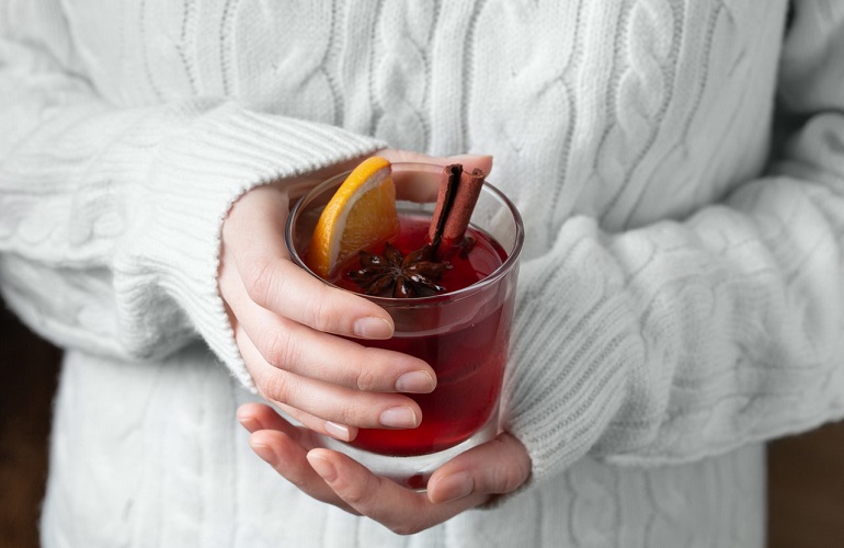A woman holding a glass of mulled wine