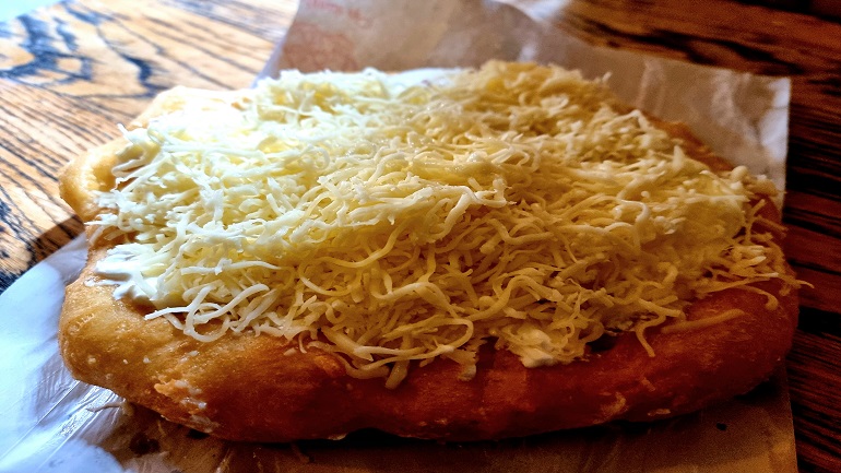 Traditional Hungarian flatbread - langos - with sour cream and grated cheese at Budapest Advent Bazilika Christmas market
